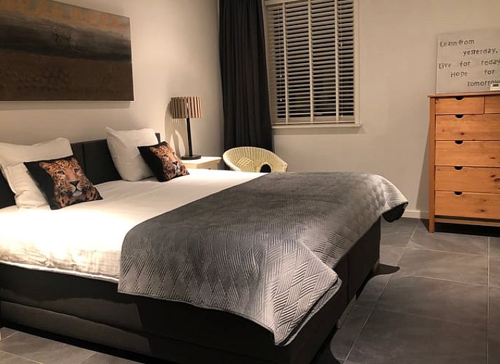 Gemuetliches Wohnzimmer im Ferienhaus in Anna Paulowna, Nordholland mit bequemer Sitzecke und Gartenblick.