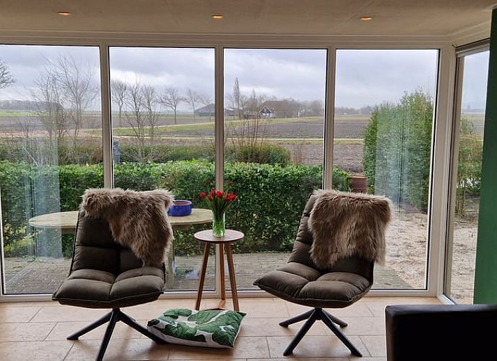 Vakantiehuis in Anna Paulowna, Waddenkust, Noord-Holland, met groene tuin en bloeiende struiken.