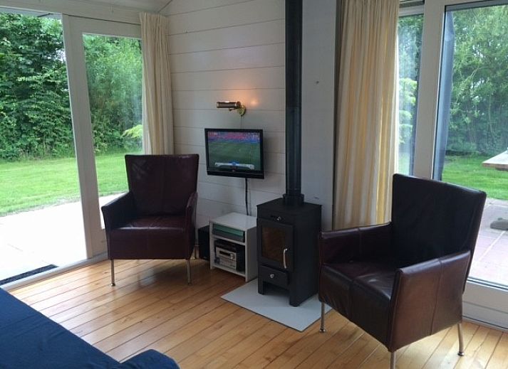 Gezellig terras van strandhuis Sandepark 31 in Callantsoog, Noordzeekust, Noord-Holland, met parasol en tuinmeubilair.