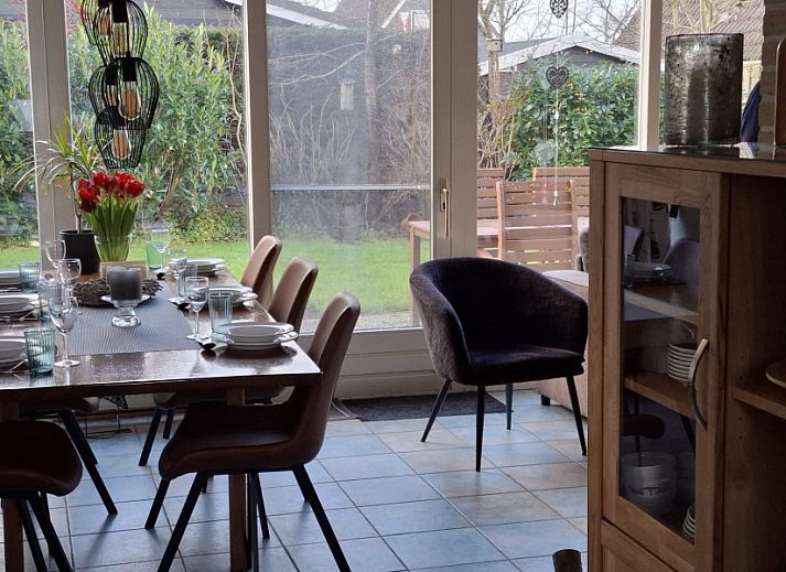 Das Ferienhaus Maike in Sint Maarten, Nordholland, bietet einen charmanten Aussenbereich mit gruener Umgebung und traditioneller Architektur.