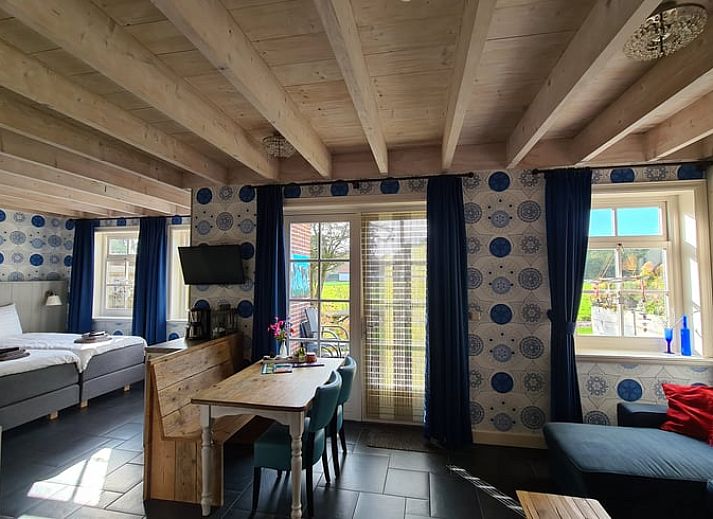 Geniet van de jacuzzi op de veranda van Huisje in Oudesluis, vakantiehuis in Noord-Holland met uitzicht op groene velden.