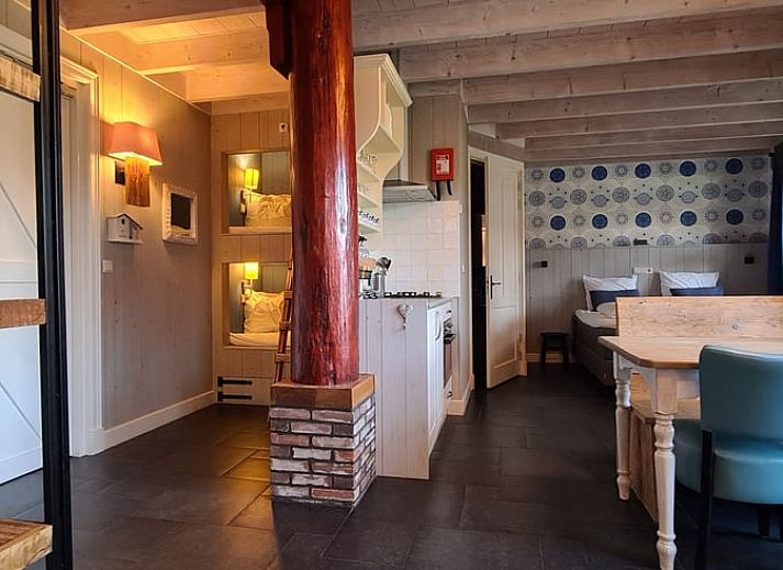 Geniet van de jacuzzi op de veranda van Huisje in Oudesluis, vakantiehuis in Noord-Holland met uitzicht op groene velden.