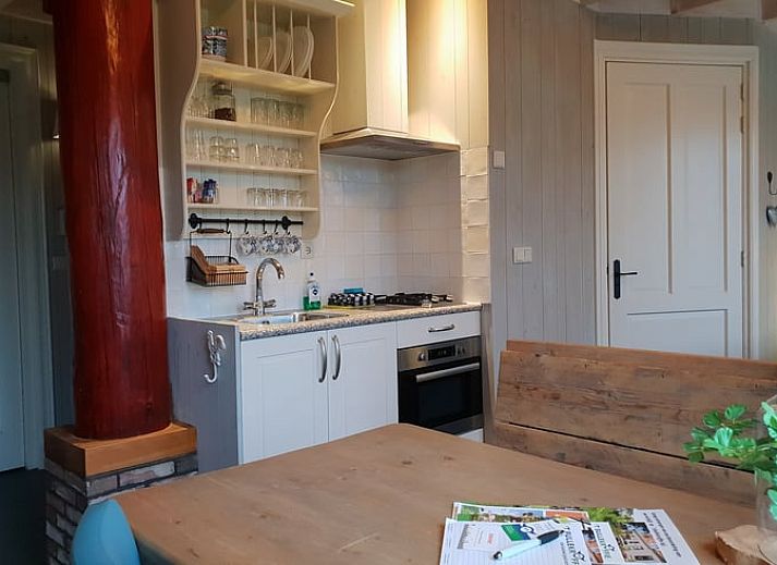 Geniet van de jacuzzi op de veranda van Huisje in Oudesluis, vakantiehuis in Noord-Holland met uitzicht op groene velden.