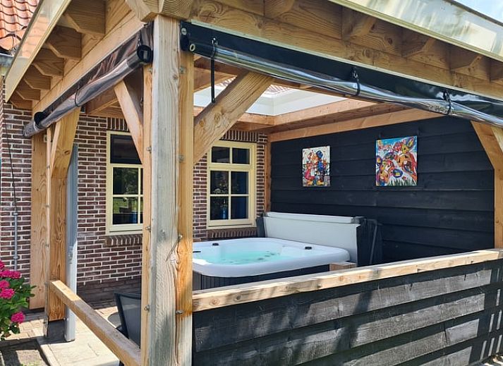 Moderne keuken in Huisje in Oudesluis, vakantiehuis in Noord-Holland, compleet met fornuis en houten eettafel.