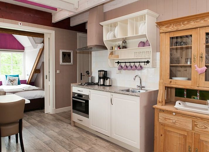 Cozy living room in Holiday Home in Oudesluis, North Holland with wooden beams and modern kitchen.