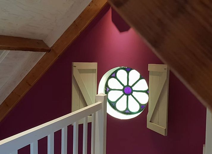 Relaxed reading by the window overlooking nature at Holiday Home in Oudesluis, North Holland.