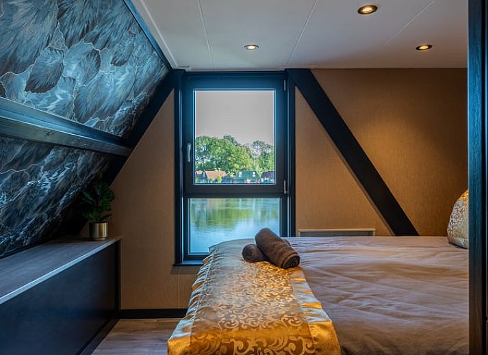 Eethoek in Vakantiehuisje in Nieuwe Niedorp met uitzicht op het terras en het serene water van Noord-Holland noord.