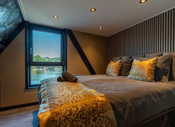 Eethoek in Vakantiehuisje in Nieuwe Niedorp met uitzicht op het terras en het serene water van Noord-Holland noord.