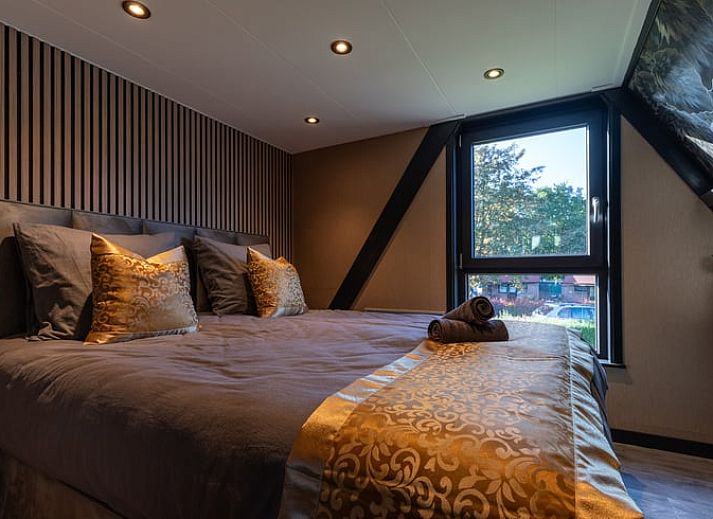 Eethoek in Vakantiehuisje in Nieuwe Niedorp met uitzicht op het terras en het serene water van Noord-Holland noord.