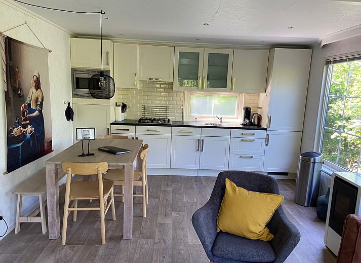 Gemuetliches Wohnzimmer des Ferienhauses Wiringherlant in Wieringen, Nordholland, mit bequemen Sitzgelegenheiten und viel Tageslicht.