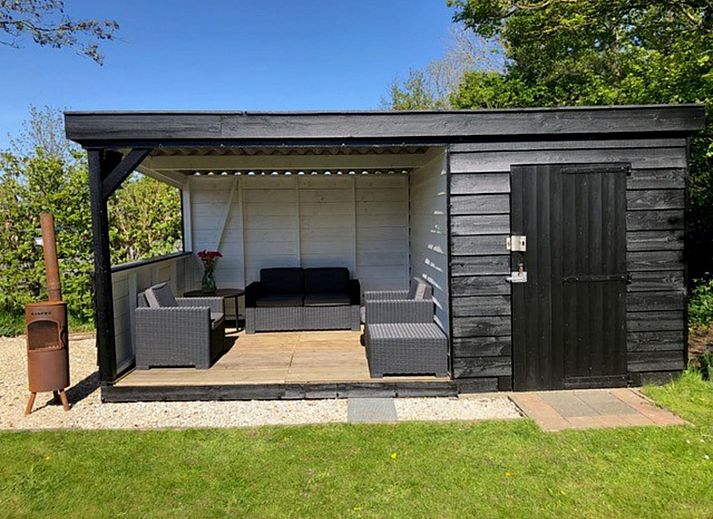 Gemuetliches Wohnzimmer des Ferienhauses Wiringherlant in Wieringen, Nordholland, mit bequemen Sitzgelegenheiten und viel Tageslicht.