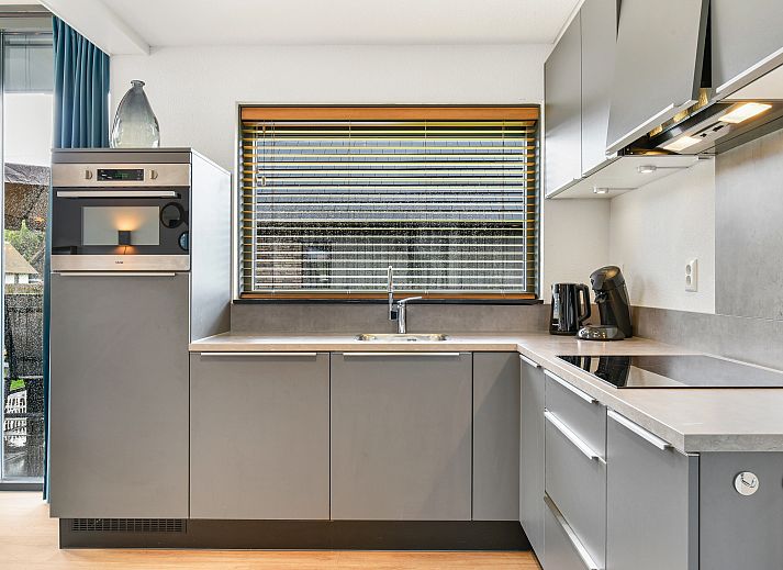 Moderne woonkamer met open keuken in Berger Duinen vakantiehuis, Schoorl.