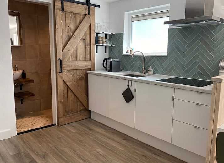 Ruhige Terrasse im Ferienhaus in Schoorl, Nordholland Nord, Nordholland, umgeben von ueppigem Gruen.