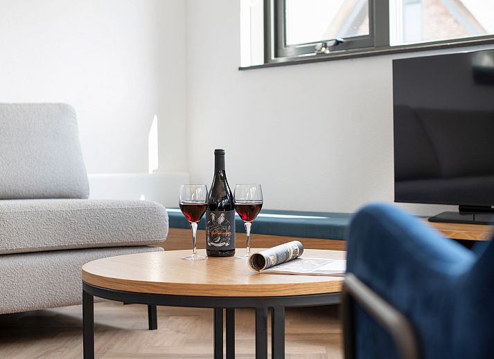 Wein und Glaeser auf dem Couchtisch im Ferienhaus Berger Duinen, Schoorl.
