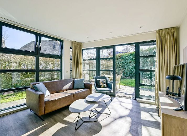 Vrijstaande woning in Schoorl, Noord-Holland, biedt een charmant vakantiehuis met rieten dak, omgeven door groene natuur en rustieke omgeving.