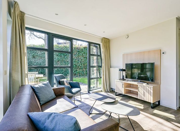 Vrijstaande woning in Schoorl, Noord-Holland, biedt een charmant vakantiehuis met rieten dak, omgeven door groene natuur en rustieke omgeving.