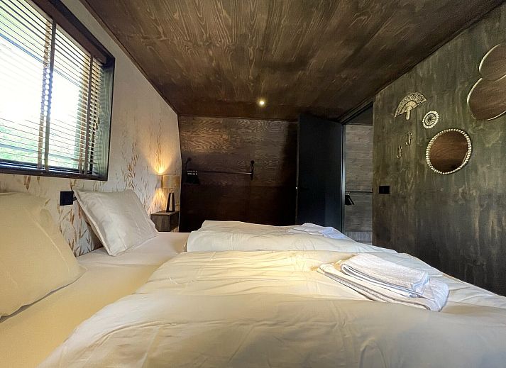 Terrasse der 6-Personen-Duinlodge Bosrand in Schoorl, Nordholland, mit Esstisch aus Holz und Blick auf die Natur.