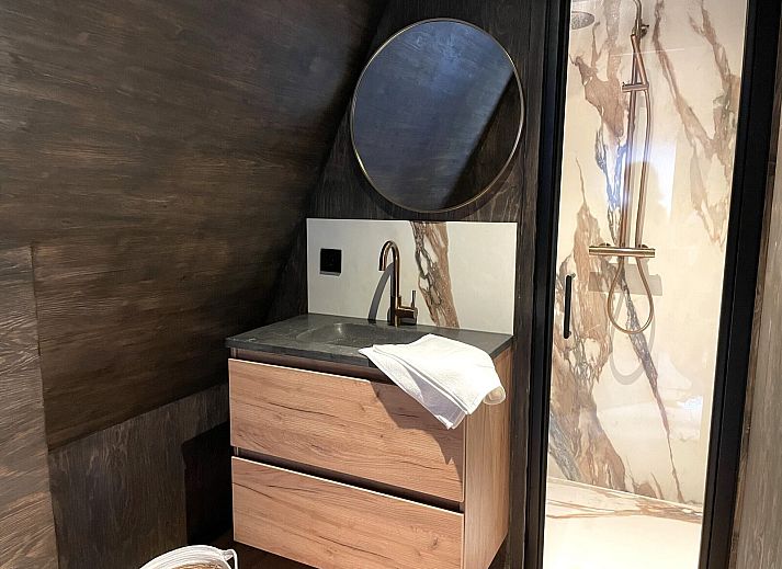 Seitenansicht des 6-Bett-Ferienhauses Duinlodge Bosrand in Schoorl, Nordholland, mit Garten und Sonnenschirm.