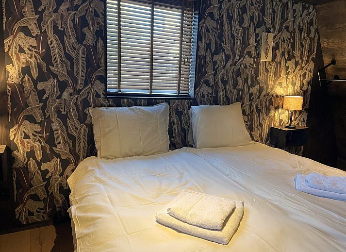 Exterior of 6-person Dune Lodge in Schoorl with thatched roof and spacious garden.