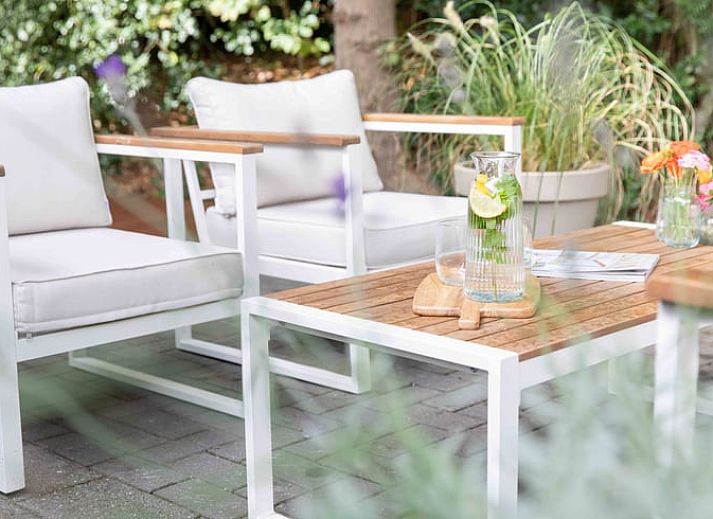 Gezellig terras van Huisje in Schoorl met bloeiende tuin in Noord-Holland noord.