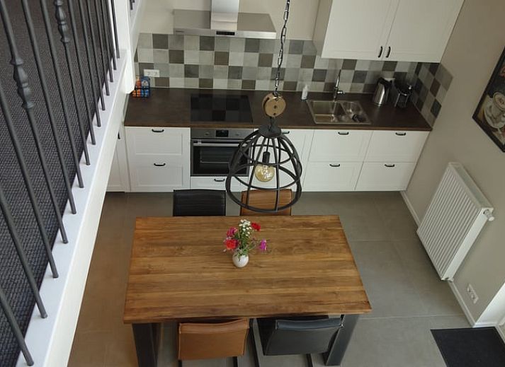 Moderne badkamer in Huisje in Schoorl, vakantiehuis in Noord-Holland met stijlvolle wastafel en mozaiek wanddetails.