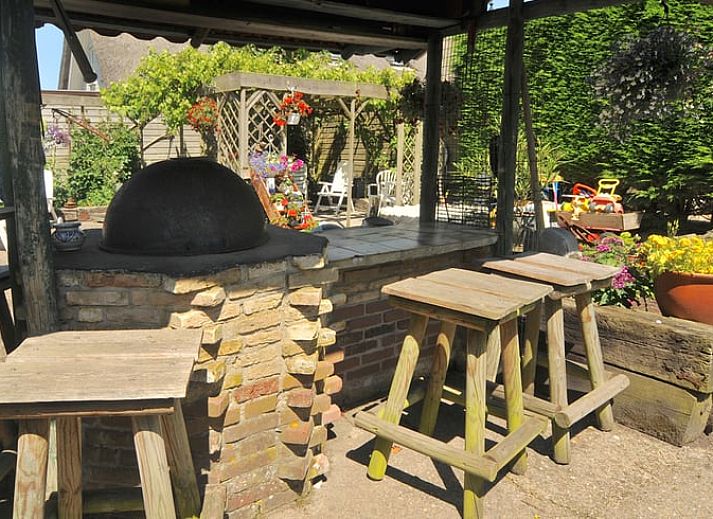 Cozy kitchen and dining area in a vacation home in Schoorl, North Holland, with rustic decor and natural light.