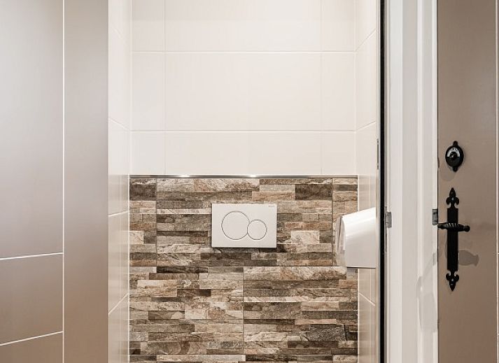 Interior of De Gouwe Droom in Bovenkarspel with cozy dining area and green accents, perfect for a family vacation on the IJsselmeer coast.