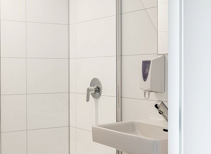 Interior of De Gouwe Droom in Bovenkarspel with cozy dining area and green accents, perfect for a family vacation on the IJsselmeer coast.