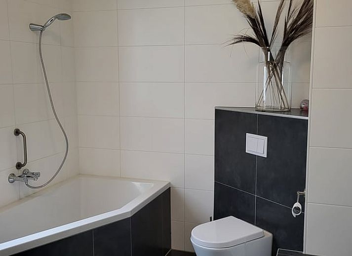 Gemuetliches Wohnzimmer im Huisje in Winkel, einem Ferienhaus in Nordholland Nord. Gemuetliche Sitzecke mit modernen Moebeln und natuerlichem Licht.