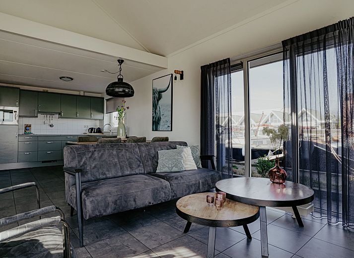 Modernes Wohnzimmer im Ferienhaus Kraaijennest Uitgeest mit gemuetlicher Sitzecke und Hafenblick.