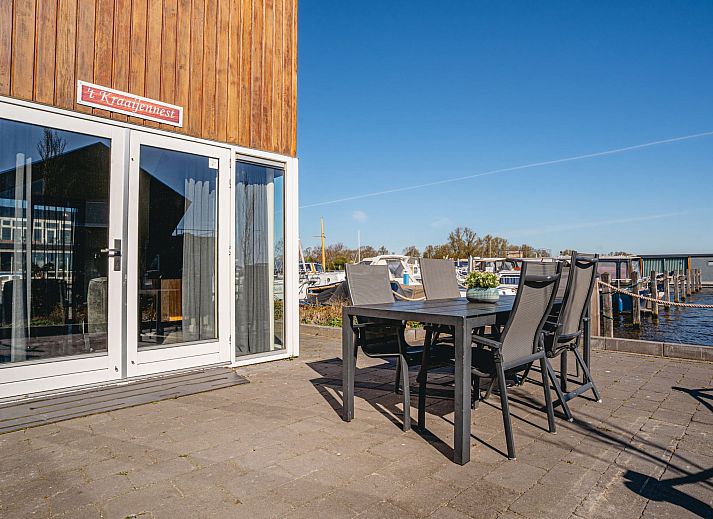 Helles Interieur des Ferienhauses Kraaijennest in Uitgeest mit grossen Fenstern und stilvollen Moebeln.