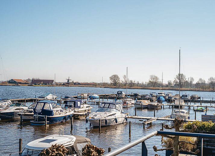 Helles Interieur des Ferienhauses Kraaijennest in Uitgeest mit grossen Fenstern und stilvollen Moebeln.
