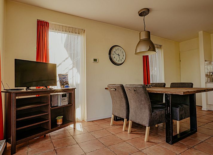 Gezellige woonkamer van Appartement Westergeest 2 in Uitgeest, Noord-Holland, met comfortabele bank en uitzicht op het meer.