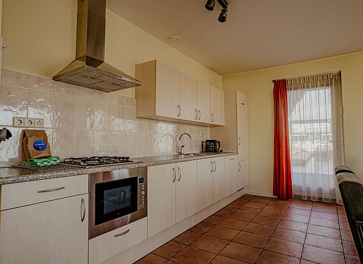 Gezellige woonkamer van Appartement Westergeest 2 in Uitgeest, Noord-Holland, met comfortabele bank en uitzicht op het meer.