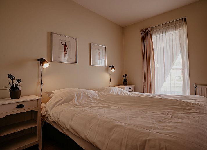 Gezellige woonkamer van Appartement Westergeest 2 in Uitgeest, Noord-Holland, met comfortabele bank en uitzicht op het meer.