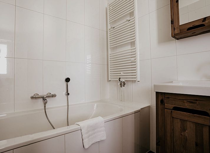 Gezellige woonkamer van Appartement Westergeest 2 in Uitgeest, Noord-Holland, met comfortabele bank en uitzicht op het meer.