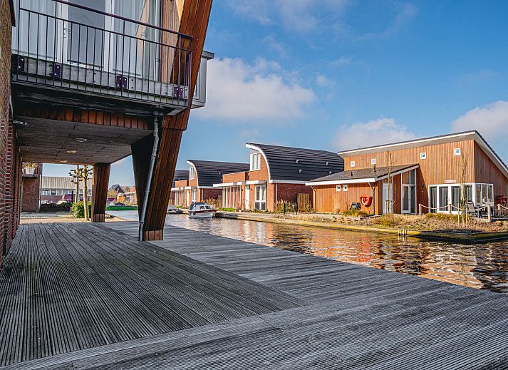 Gezellige woonkamer van Appartement Westergeest 2 in Uitgeest, Noord-Holland, met comfortabele bank en uitzicht op het meer.