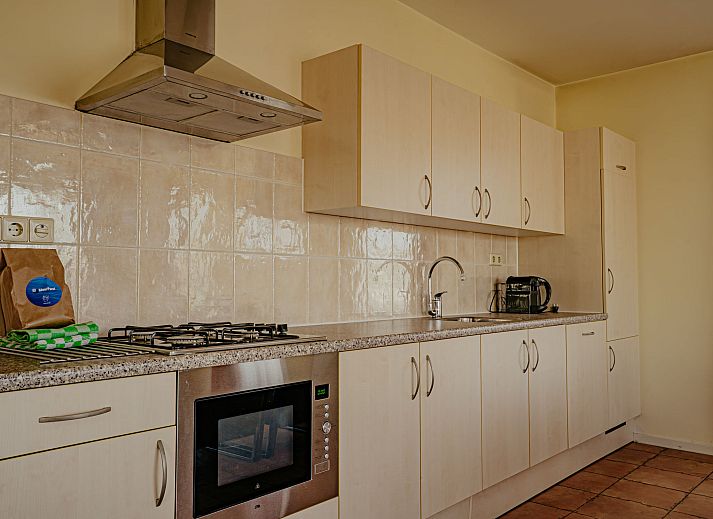 Eetkamer en keuken in Appartement Westergeest 2, Uitgeest, Noord-Holland, met moderne faciliteiten en stijlvolle inrichting.