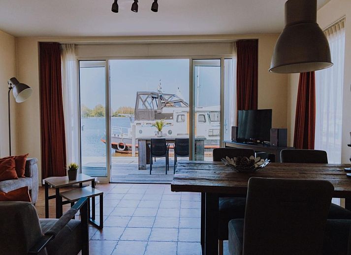 Ferienhaus auf Wasserbasis in Uitgeest, Nordholland, mit moderner Fassade und gruener Umgebung.