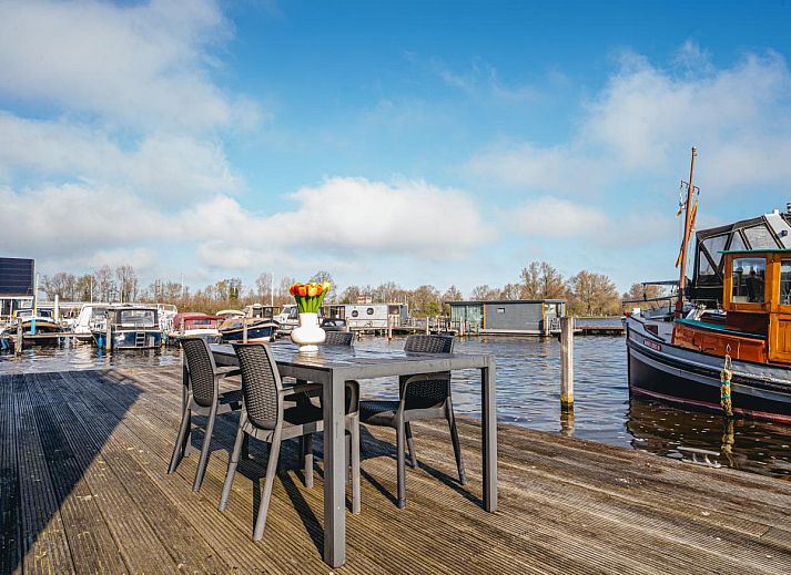 Esszimmer und Sitzecke im Ferienhaus Waterbase, Uitgeest, Nordholland fuer einen entspannten Aufenthalt.