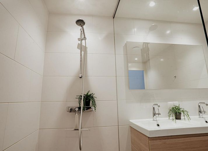 Ruime woonkamer van vakantiehuis Waterfront in Uitgeest, Noord-Holland met moderne inrichting en veel natuurlijk licht.