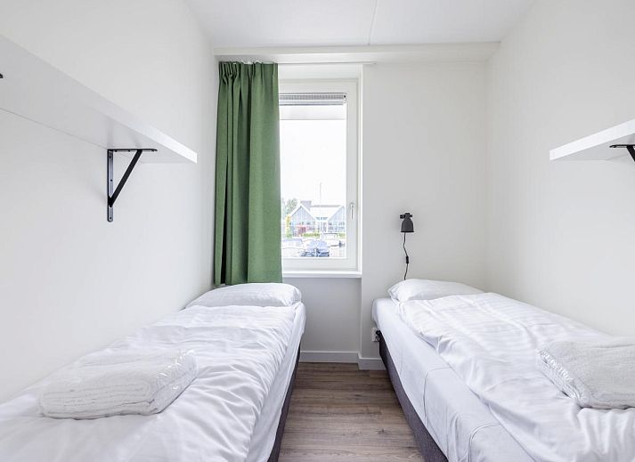 Gemuetliches Wohnzimmer im Ferienhaus Lakehouse I, Uitgeest, Nordholland, mit moderner Einrichtung und Blick auf die Terrasse.