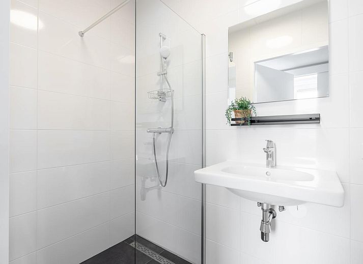 Gemuetliches Wohnzimmer im Ferienhaus Lakehouse I, Uitgeest, Nordholland, mit moderner Einrichtung und Blick auf die Terrasse.