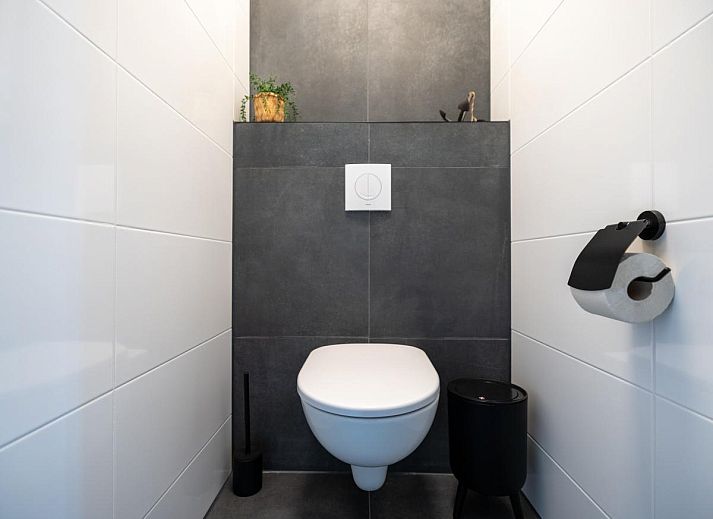 Gemuetliches Wohnzimmer im Ferienhaus Lakehouse I, Uitgeest, Nordholland, mit moderner Einrichtung und Blick auf die Terrasse.