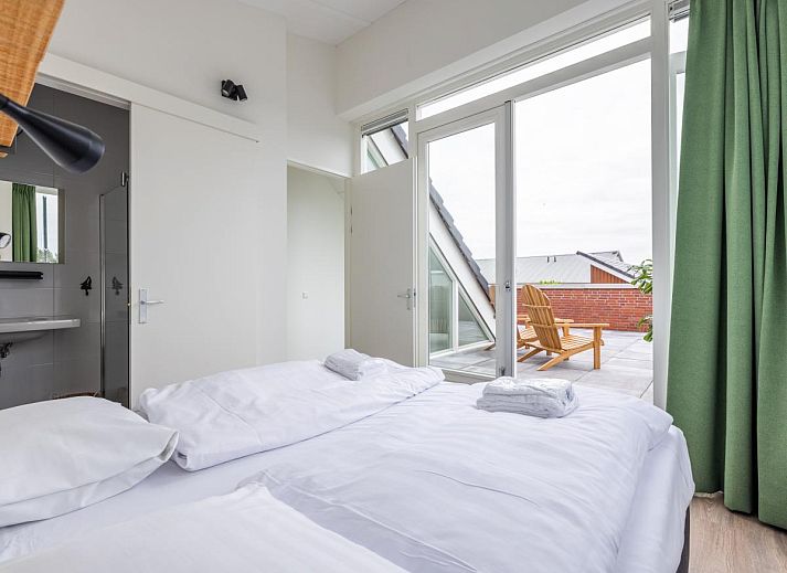 Gemuetliches Wohnzimmer im Lakehouse I, einem Ferienhaus in Uitgeest, Nordholland, mit herrlichem Blick auf den Yachthafen.