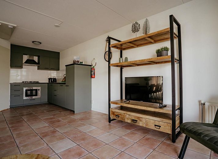 Gemuetliches Wohnzimmer des Ferienhauses Busch en Dam in Uitgeest, Nordholland, mit moderner Einrichtung und Blick auf den Garten.