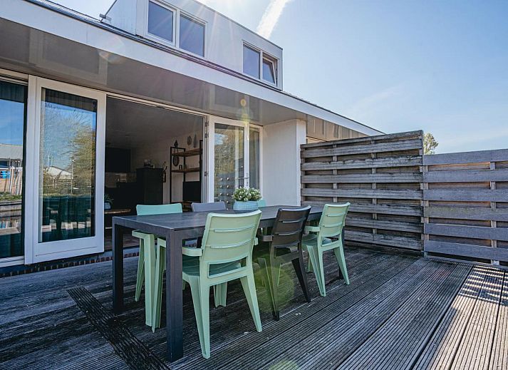 Gemuetliches Wohnzimmer des Ferienhauses Busch en Dam in Uitgeest, Nordholland, mit Blick auf die Terrasse und moderner Einrichtung.