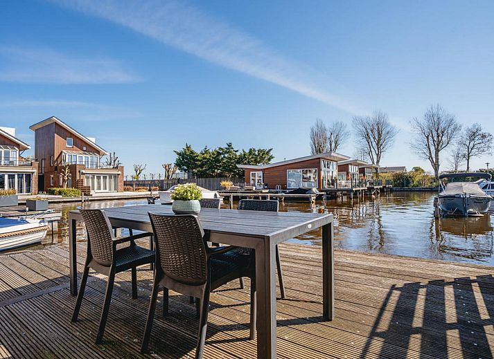 Gemuetliches Wohnzimmer des Ferienhauses Busch en Dam in Uitgeest, Nordholland, mit Blick auf die Terrasse und moderner Einrichtung.
