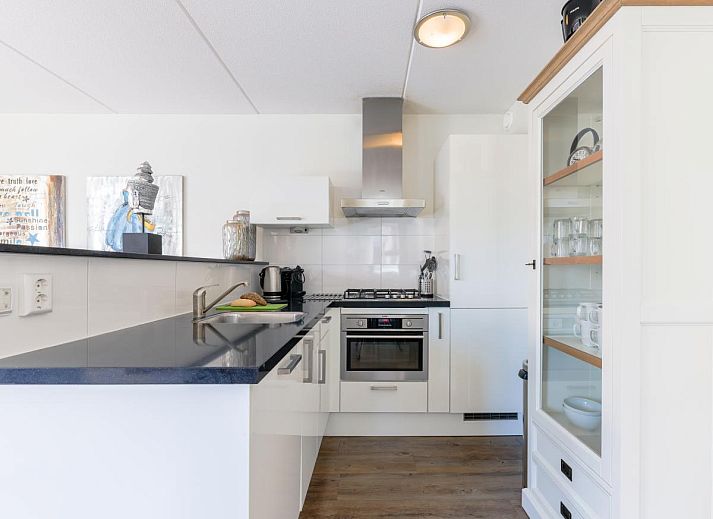 Enjoy the sunny terrace of Apartment Assum I in Uitgeest, North Holland, with views of the water and comfortable outdoor seating.