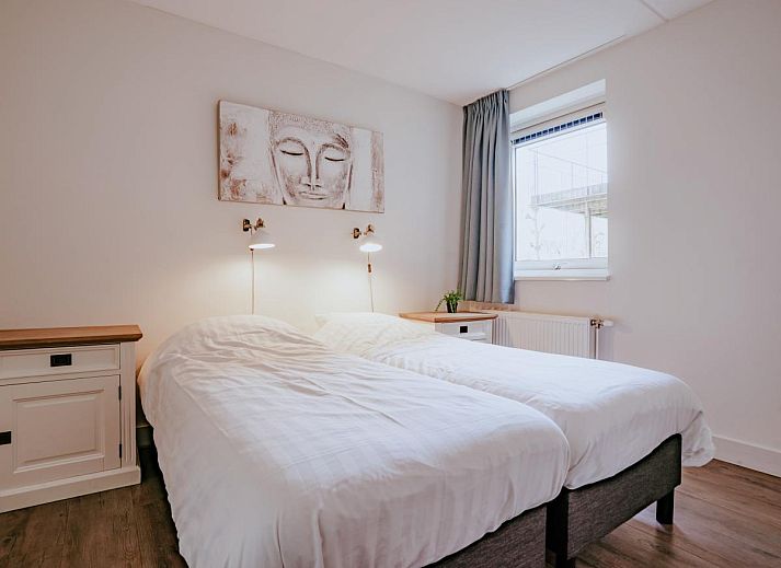 Enjoy the sunny terrace of Apartment Assum I in Uitgeest, North Holland, with views of the water and comfortable outdoor seating.